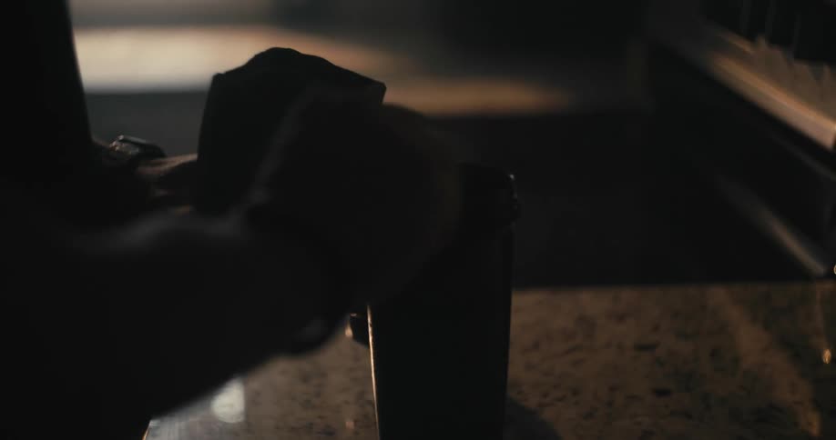 Mans hand putting a supplement into his shaker bottle