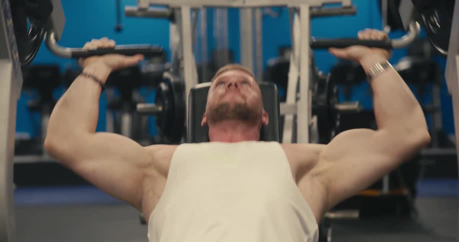 A man at the gym doing arm exercises on a machine