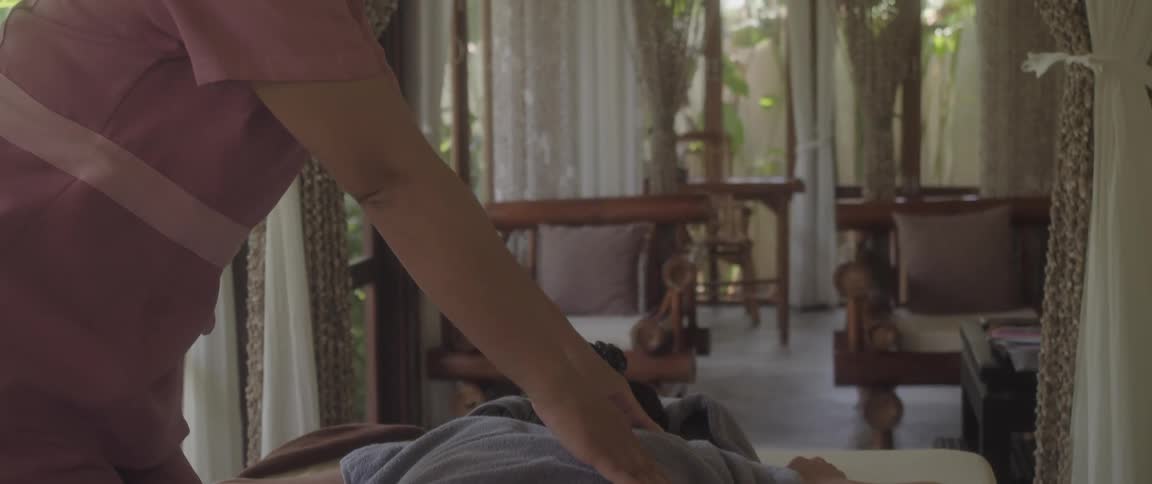 Masseuse rubs a clients back on a beautiful spa