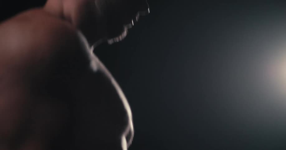 A shirtless man drinks a smoothie after working out