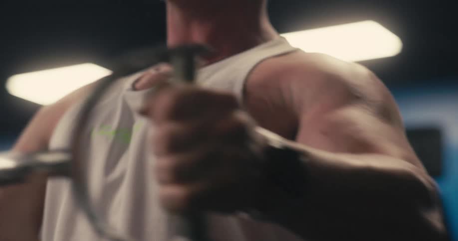 A man wearing a watch is working out his arms with a machine