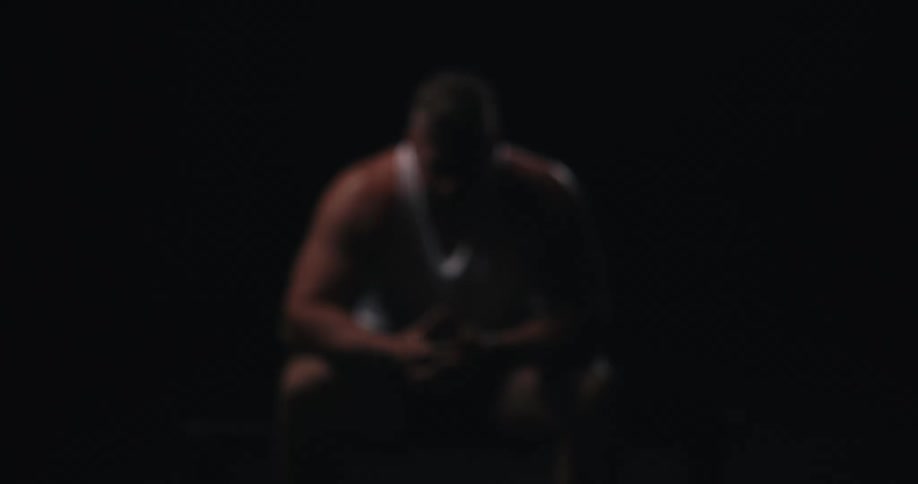 A sad sitting man wearing a white shirt