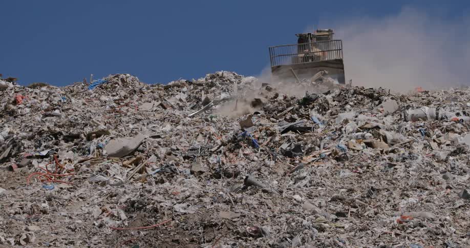 Truck organizing garbage at a landfill