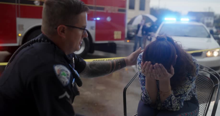 Woman crying and being comforted by the police officer beside her