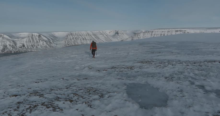 Man hiking on top of icecovered mountains