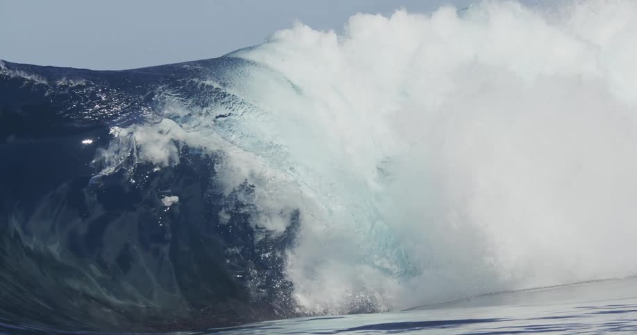 A big sea wave breaking and raising drops and foam