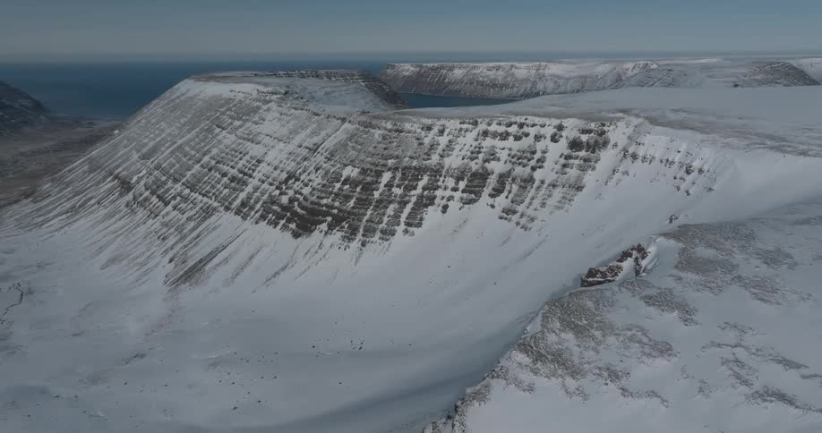 Aerial of a coastal island with snow capped mountains
