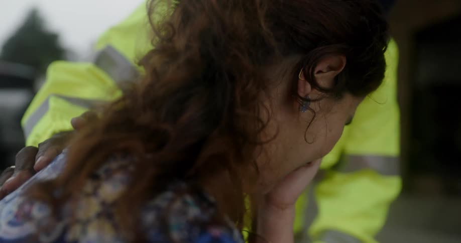Woman wipes tears away as man puts a hand on shoulder to comfort her