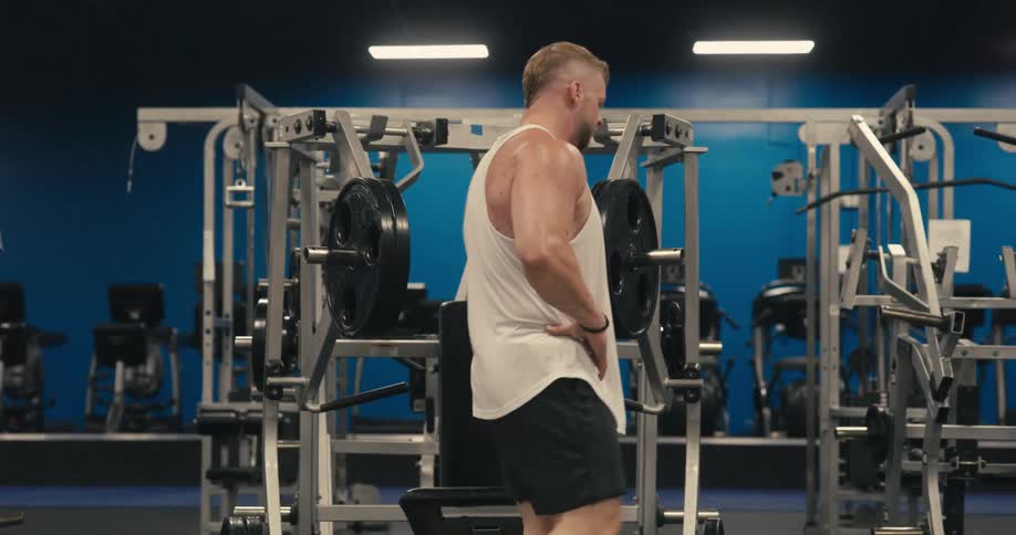 Man with hands on his waist sweating and walking in a gym