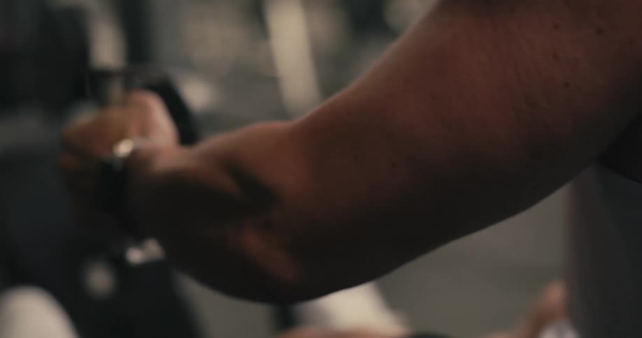 Man works out using weight machine in gym