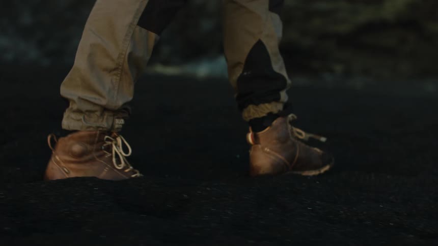 Person wearing brown lace up boots treks across land
