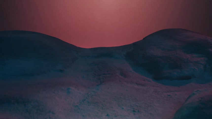 Light shines from red hazy sky onto rough stony ground