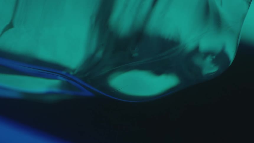 Water drops fall from thawing ice in dark area