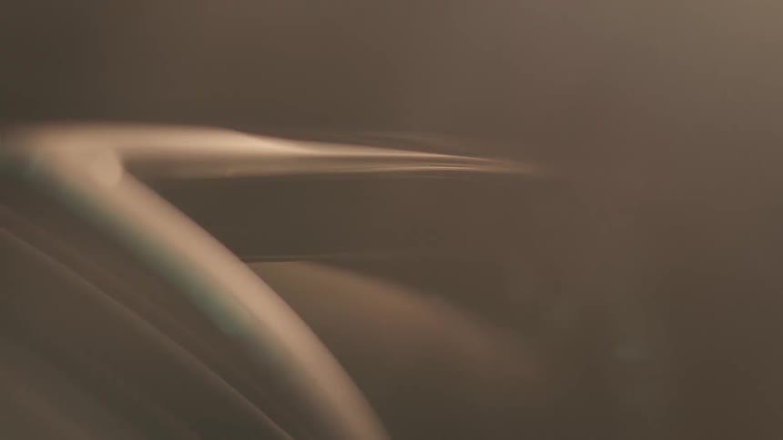 Fog flows across vehicle headlight at night