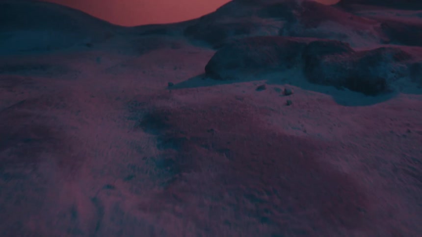 Snow covers terrain under a red sky on a hazy day