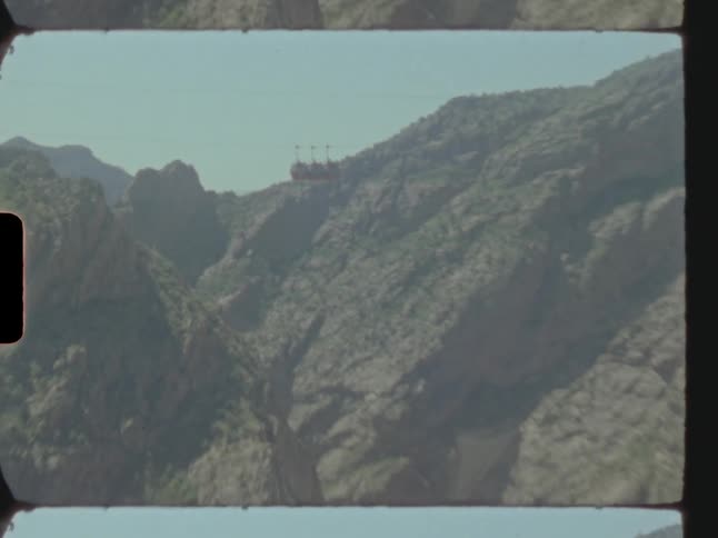 A rail car with three carts on it over large mountain valleys