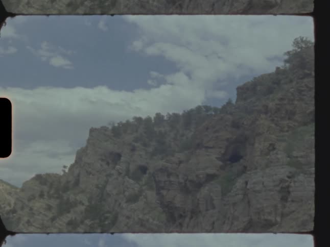 Mountain and cliffs with clouds across the sky during the day