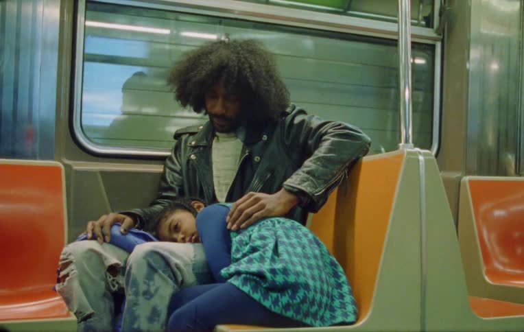 Daughter lying on her fathers lap inside a moving train
