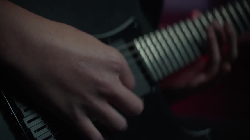 A person playing a black guitar