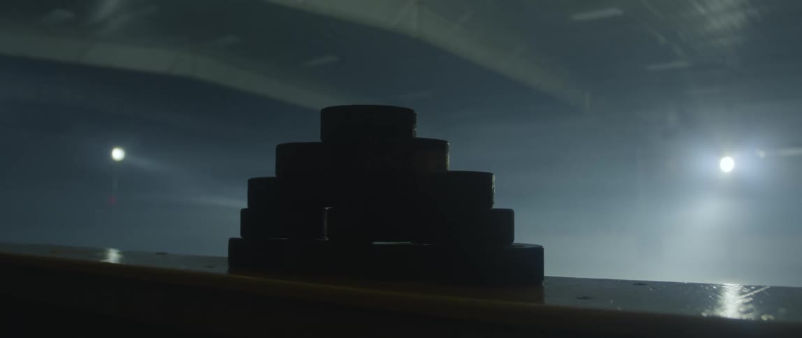 Man placing hockey pucks on the ice rink