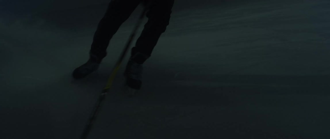 Man playing ice hockey alone indoor at night