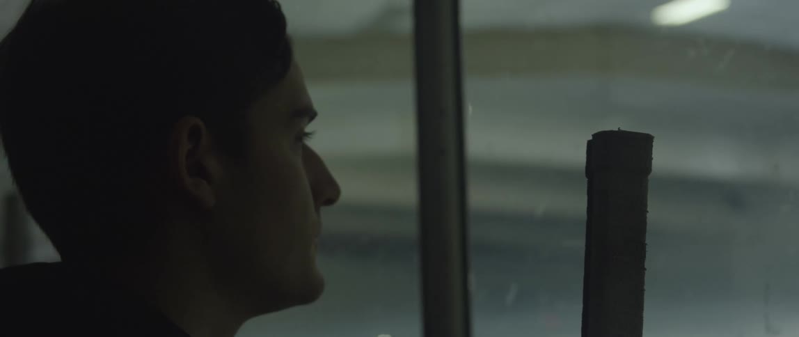 A young boy walking up to the glass at a hockey rink