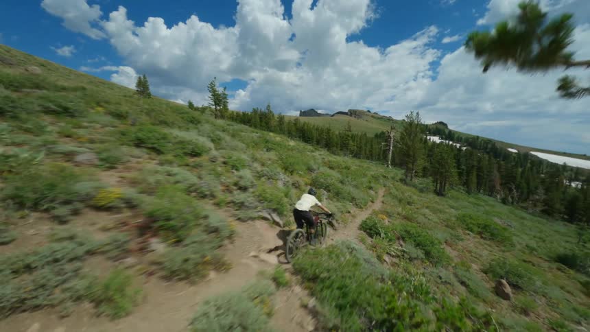Aerial view of a cyclist riding a bicycle on a trail in the mountains