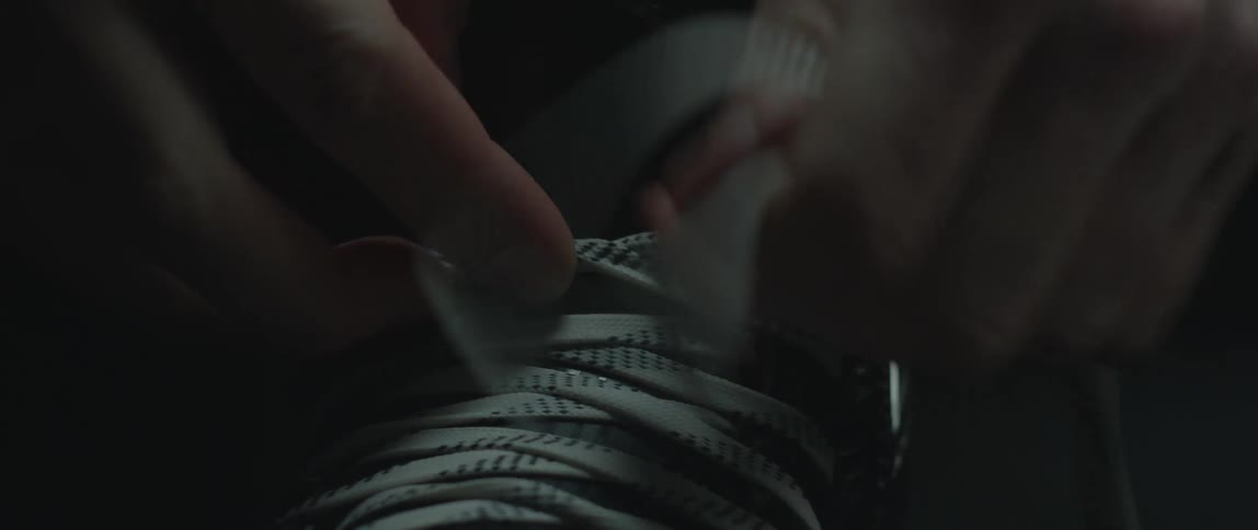 A person tying a hockey skate