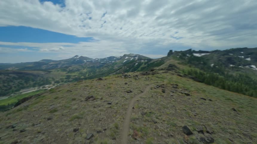 A person riding their bike on a mountain trail in the middle of the day