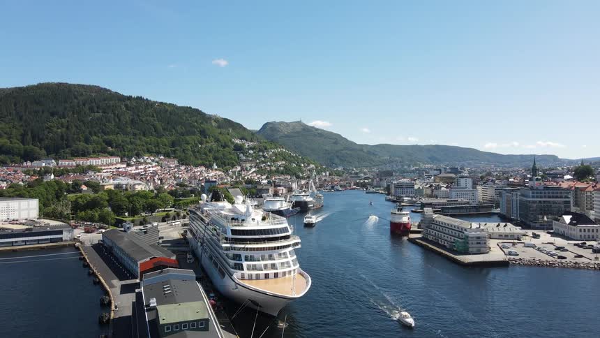 Drone view of cruise ships at a marina with smaller boats and ships docked and sailing in the waterway