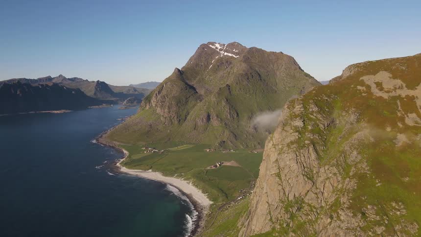 Drone view of mountain ranges on a coastline with a plateau in between the mountains