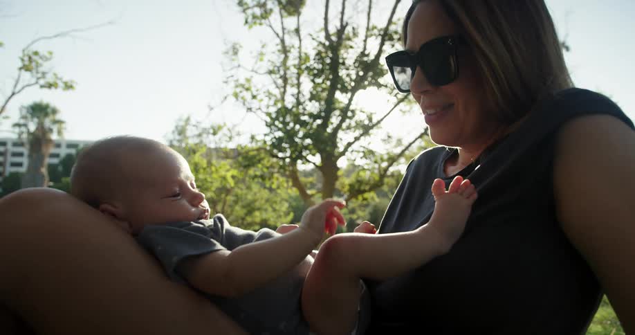 Mother sitting with her baby son resting on her lap