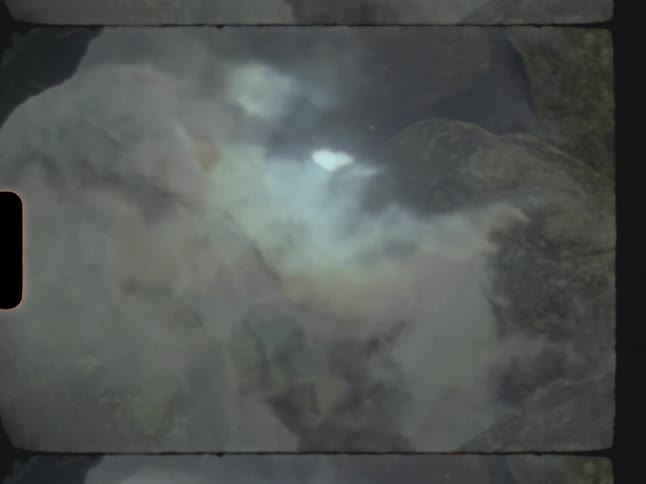 A puddle of water with gray stones at the bottom