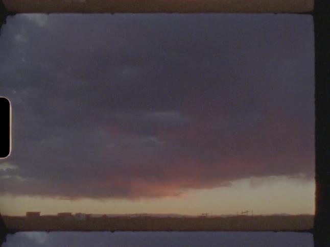 View of the horizon with a pasture and a red sky with clouds