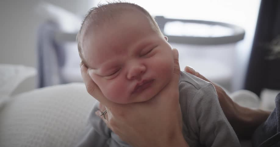 Mother putting her newborn baby to sleep