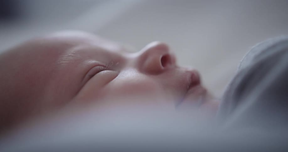 Baby smiles in its sleep while lying on its back