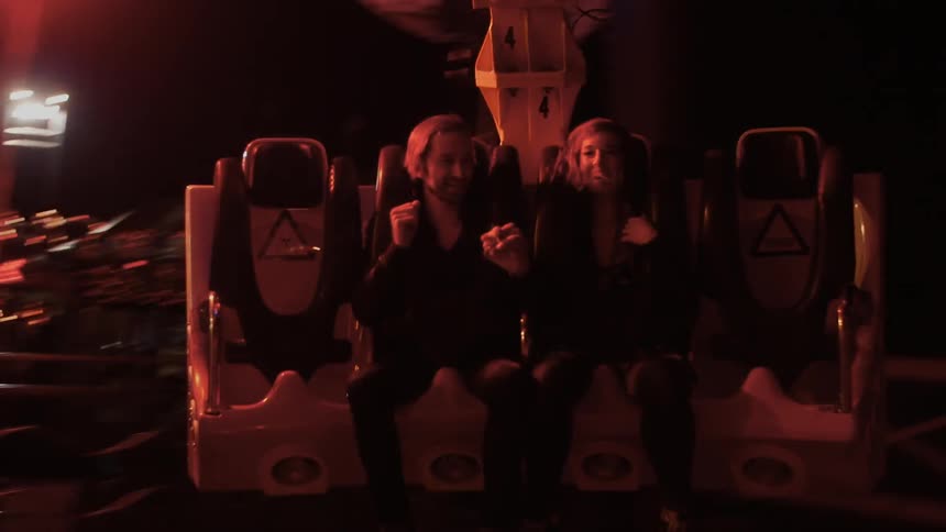People riding in amusement ride at night
