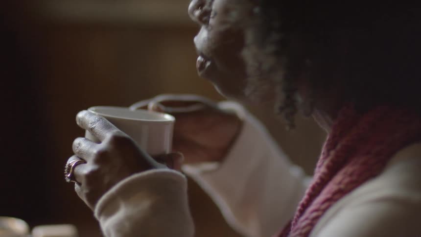 A woman is drinking from a mug