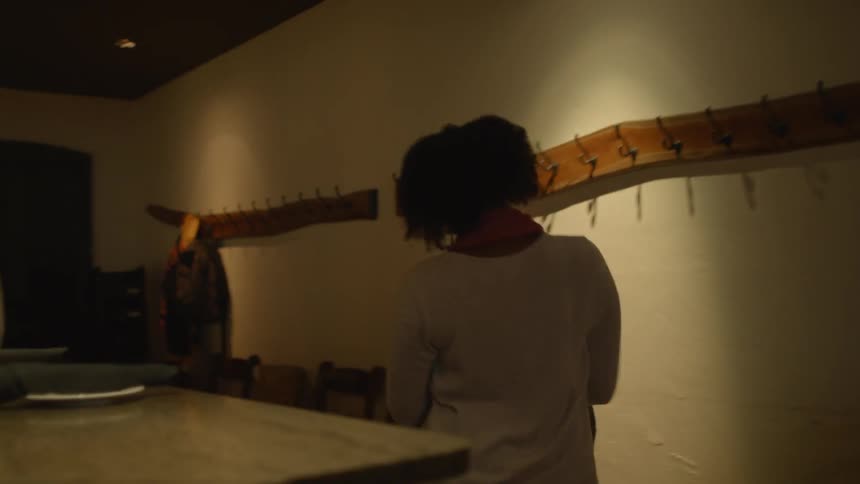 A woman walks into a restaurant kitchen
