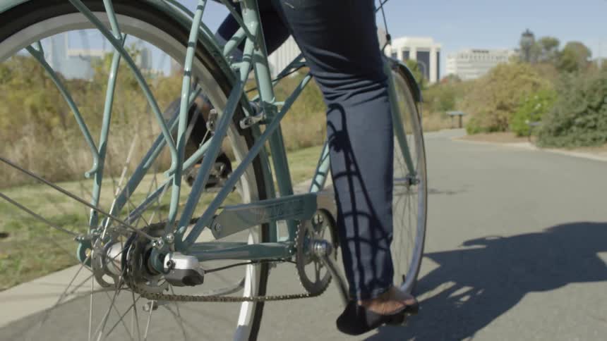 A person pedals a bicycle on a path