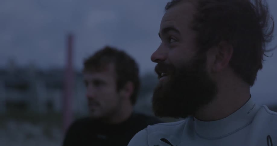 Two men stand outside at dawn