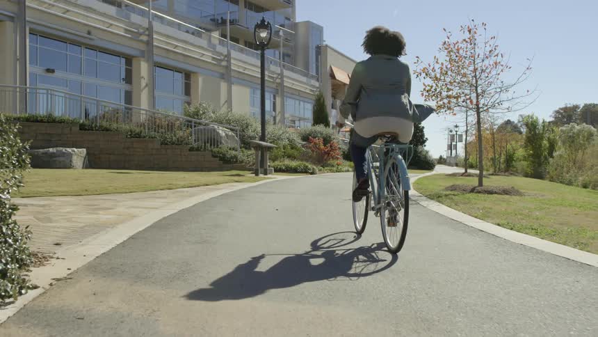 Woman rides her bike up to an office building