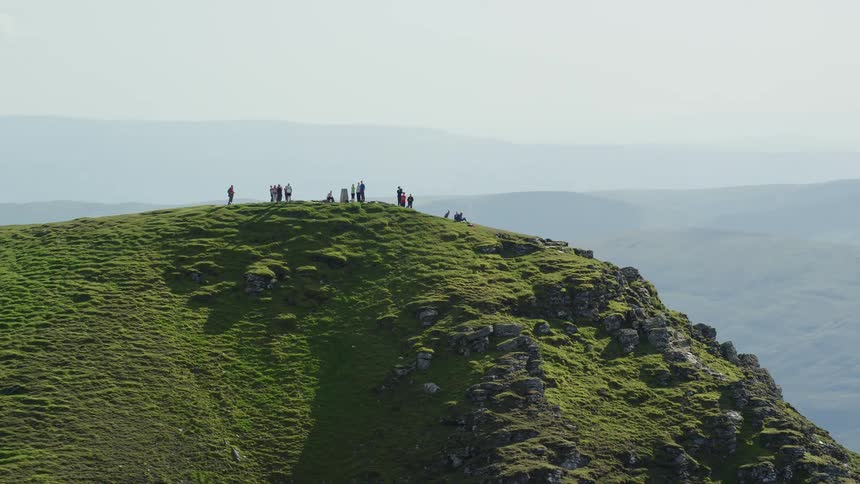 A group of hikers stand on top of a tall cliff