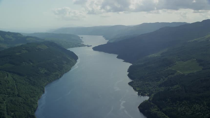 Aerial view of a central lake surrounded by forestcovered mountains