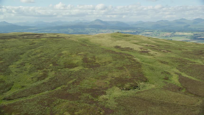 Aerial view of mountains and rural fields on a sunny day