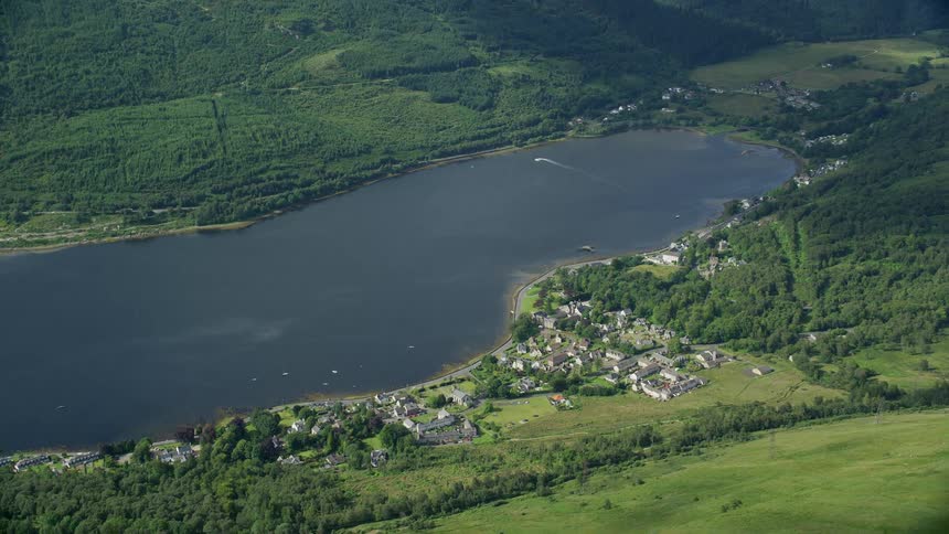An aerial of a small lakeside community surrounded by forested hills