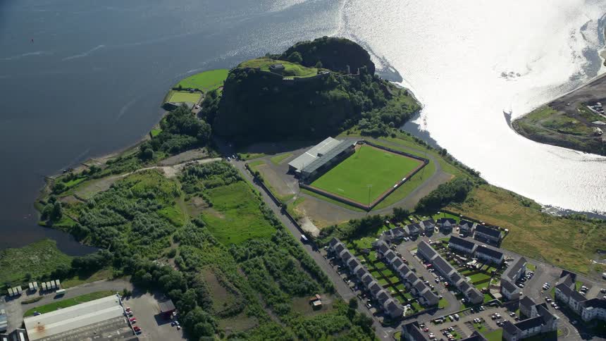 Aerial view of an urban area with some grassy fields vegetation and by the river