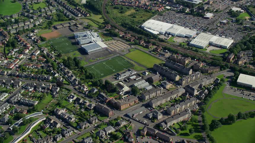 Urban city aerial with houses and football fields