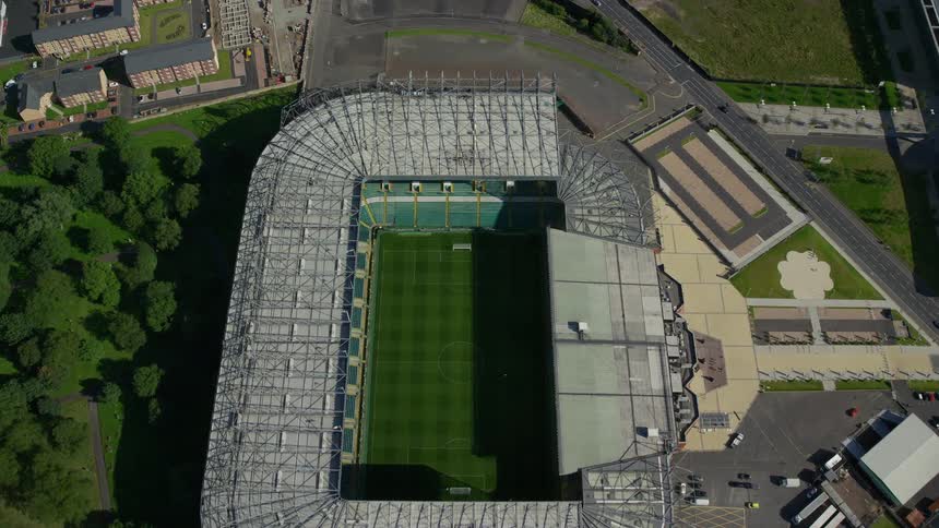 Aerial of a sports stadium with a soccer field inside with an open top on a bright sunny day