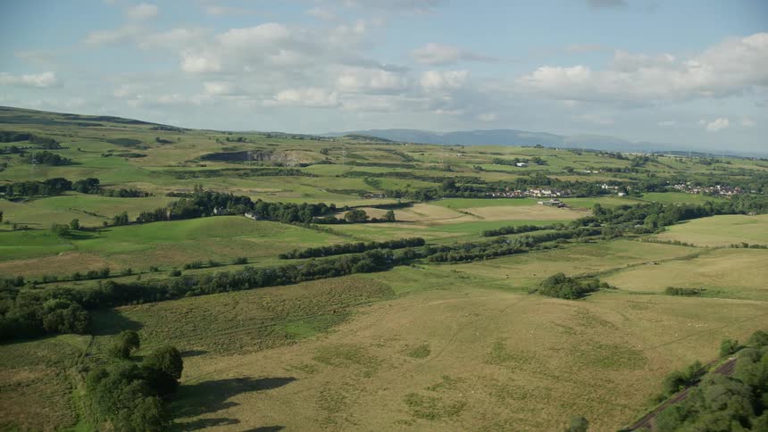 A field of low vegetation and grassy fields in the middle